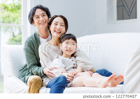微笑的父母和孩子坐在客廳的沙發上 122770487