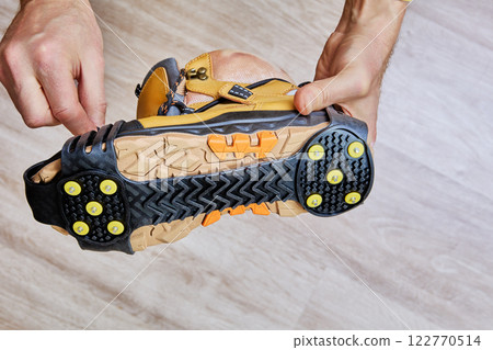 Traction cleats attached to boot sole provide enhanced grip and safety for walking on snow and ice. 122770514