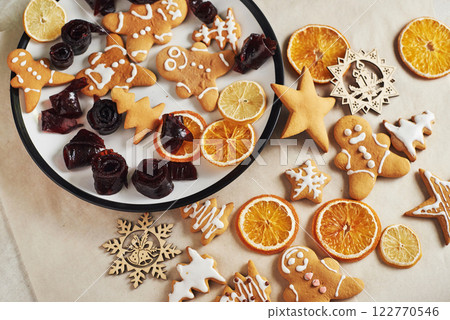 Christmas gingerbread cookies and dried orange and spices on white table. Pastel, jam in rolls on a plate Christmas gingerbread cookies and dried orange and spices on white table. Pastel, jam in rolls on a plate 122770546