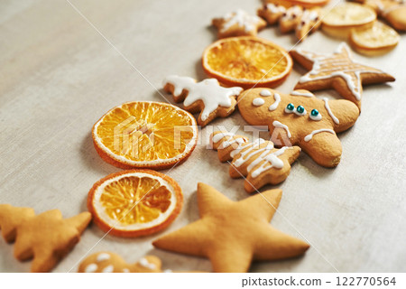 Christmas gingerbread cookies and dried orange and spices on white table Christmas gingerbread cookies and dried orange and spices on white table 122770564
