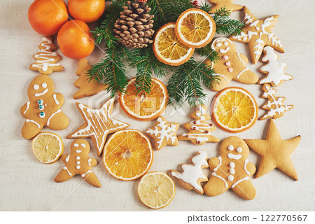 Christmas gingerbread cookies and dried orange and spices on white table. Chairs Christmas trees, cones and Christmas decorations Christmas gingerbread cookies and dried orange and spices on white table. Chairs Christmas trees, cones and Christmas decorations 122770567
