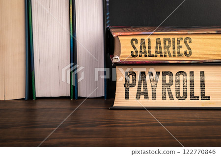 Payroll and Salaries Concept. Stack of books on a wooden shelf Payroll and Salaries Concept. Stack of books on a wooden shelf 122770846