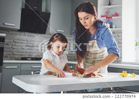 A beautiful daughter with her mother bakes New Year's greetings. Merry Christmas 122770974
