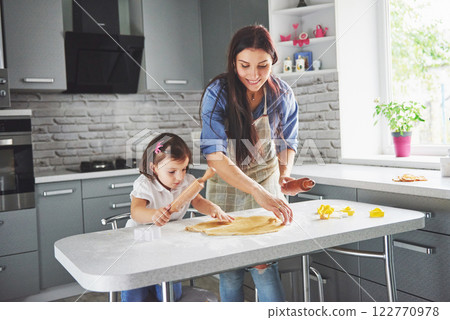 Mom loving the oven for the daughter of the cookie. 122770978