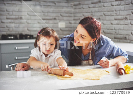 Mom loving the oven for the daughter of the cookie. 122770989