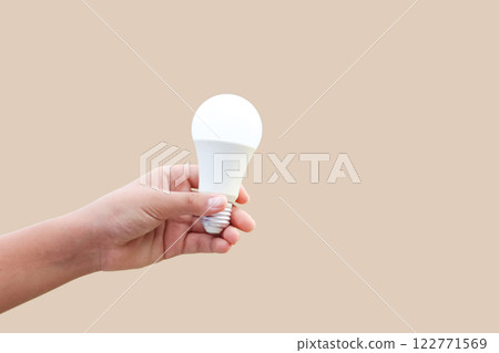 A cutout image of a hand holding a white light bulb, isolated with clipping paths. 122771569