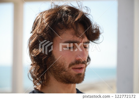 Long Haired Man Stares Into Void Immersed in His Thoughts and Thinking 122772172