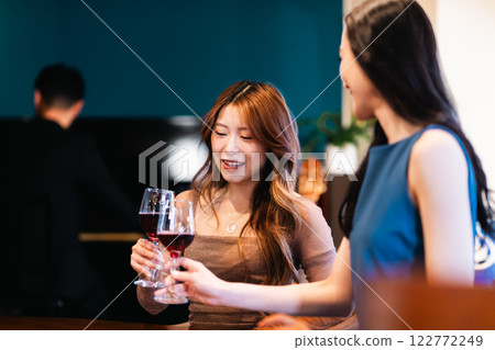 年輕女子在酒吧舉起酒杯 122772249