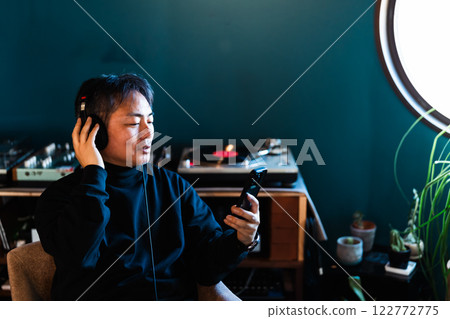 Middle-aged man enjoying music with headphones 122772775