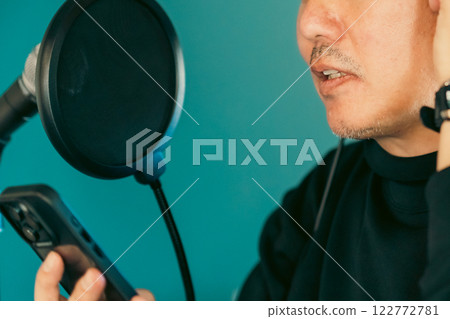 中年男子一邊看智慧型手機上的歌詞一邊唱歌,沒有臉 中年男子一邊看智慧型手機上的歌詞一邊唱歌,沒有臉 122772781