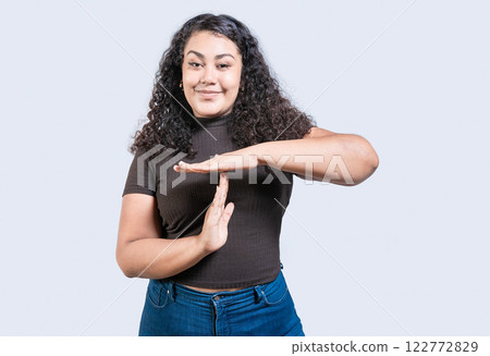 Smiling woman showing time out gesture isolated. Young woman making time out gesture with palms isolated Smiling woman showing time out gesture isolated. Young woman making time out gesture with palms isolated 122772829