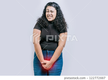 Girl with hands on crotch with urinary problems. People with urinary incontinence on white background. Young woman with urinary problems isolated 122772887
