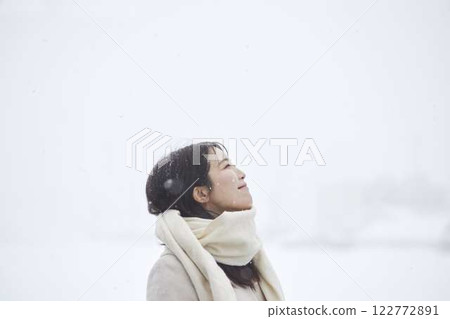 A Japanese woman wearing a scarf standing in a snowy winter country A Japanese woman wearing a scarf standing in a snowy winter country 122772891