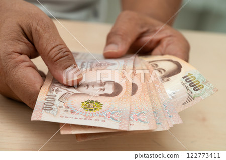 Asian woman holding Thai banknotes money, economy finance exchange trade investment. 122773411
