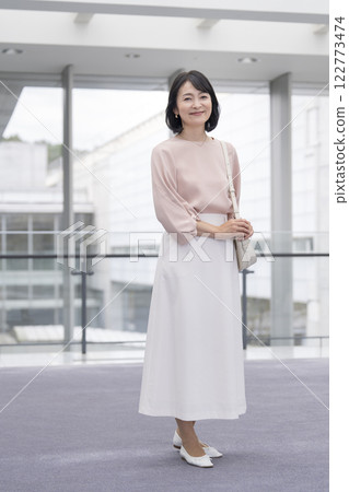 Woman in her 50s smiling at the camera, full body portrait 122773474