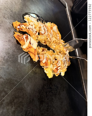 Delicious tonpeiyaki grilled on a hot plate 122773592