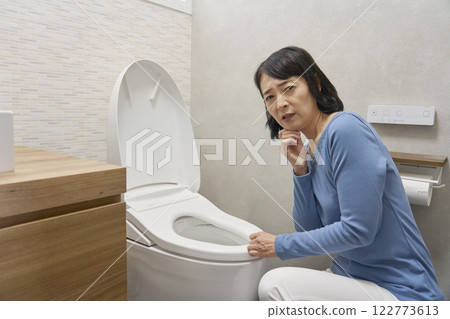 女人擔心廁所故障，看著相機 122773613