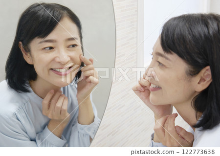 50多歲的女人照鏡子做臉部皮膚護理 122773638