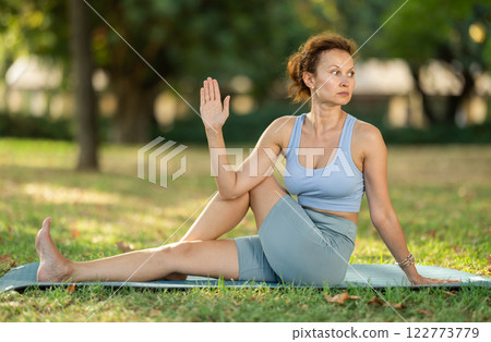 Adult woman doing stretching in park 122773779