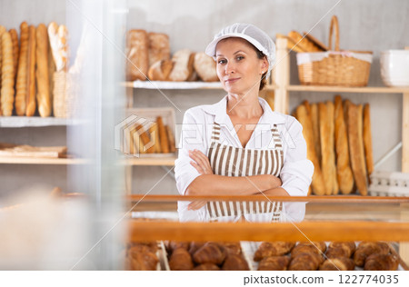bakery worker shows off a variety of different crescent-shaped buns. 122774035