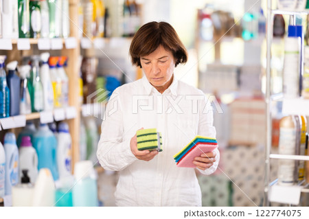 Elderly woman chooses sponges in store 122774075