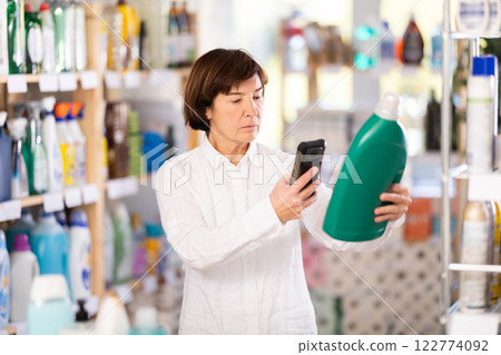 Elderly woman scanning qr code for detergent Elderly woman scanning qr code for detergent 122774092