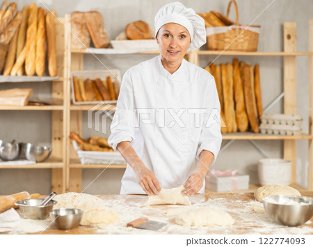 Woman works as baker in bakery, molds pies from dough, creates croissants from dough. Woman works as baker in bakery, molds pies from dough, creates croissants from dough. 122774093