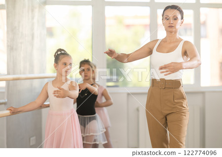 Teacher dancer performing pirouette in front of class 122774096