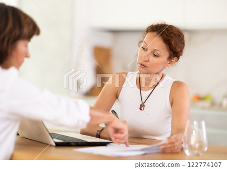 Woman listen attentively and intently to woman of seller, who tells about advantages of making microloan in credit institution 122774107