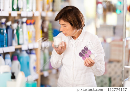 Female shopper chooses scented candles in supermarket for romantic evening Female shopper chooses scented candles in supermarket for romantic evening 122774157