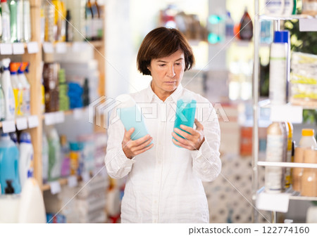 Elderly woman choosing shampoo or shower gel in store 122774160