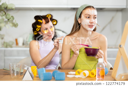Women apply mask to their face with brush and use patches Women apply mask to their face with brush and use patches 122774179
