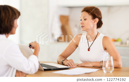 Female insurance agent tells woman the terms of property and life insurance 122774192