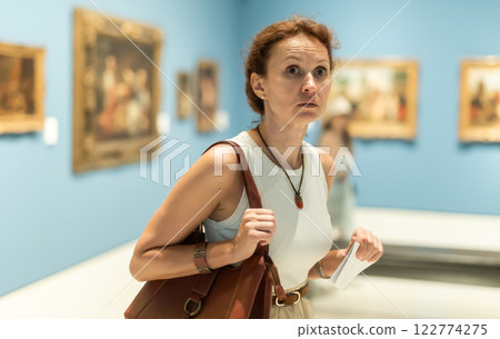 Woman viewing art gallery with brochure 122774275