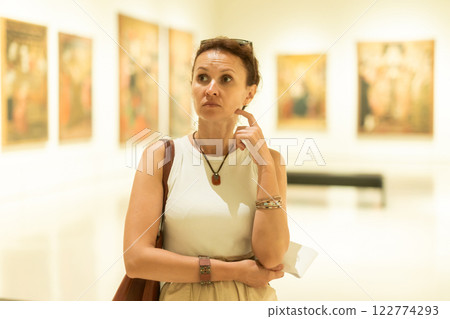 Woman viewing art gallery with brochure Woman viewing art gallery with brochure 122774293