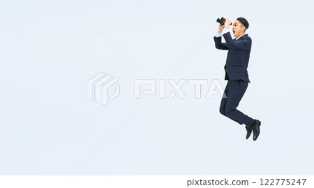 一位中年男性商務人士拿著雙筒望遠鏡跳躍的全身照片 一位中年男性商務人士拿著雙筒望遠鏡跳躍的全身照片 122775247