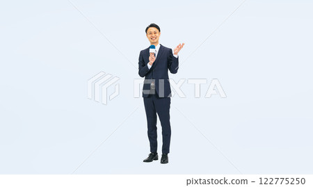 一位中年男性商務人士拿著麥克風做報告的全身照片 122775250