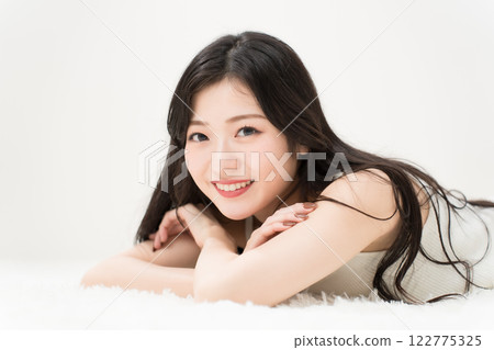 美女圖片：面帶微笑的年輕女子躺著，看著相機 122775325