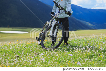 Riding mountain bike on flowering grassland mountain Riding mountain bike on flowering grassland mountain 122776342