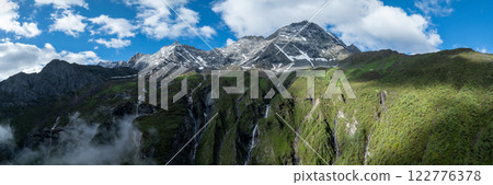 Aerial view of beautiful high altitude snow capped mountain and forest landscape 122776378