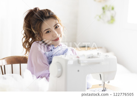 Cute woman using a sewing machine 122776505
