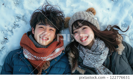 一對快樂的年輕夫妻躺在雪地上 122776631