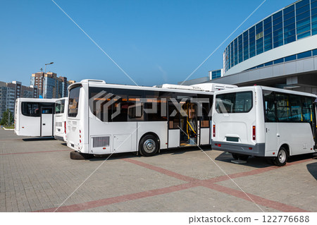 White city buses at the bus station on a clear day White city buses at the bus station on a clear day 122776688