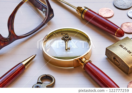 Key and magnifying glass on a notebook Key and magnifying glass on a notebook 122777259