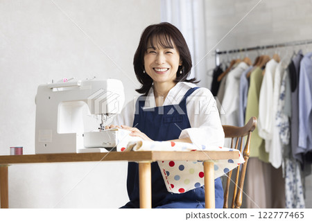 Woman using a sewing machine Woman using a sewing machine 122777465