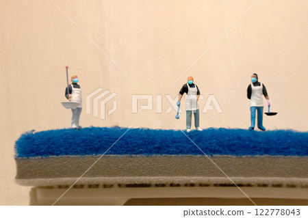 A small person doing spring cleaning standing on a sponge A small person doing spring cleaning standing on a sponge 122778043