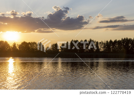 the lake with orange water in the summer at sunset the lake with orange water in the summer at sunset 122778419