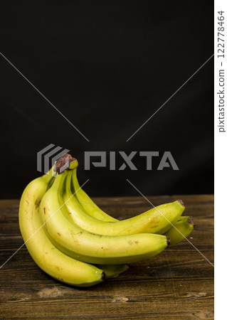 a ripe banana with a yellow-green peel is on the table 122778464