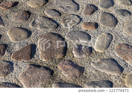 a part of the road made of cobblestones, an old-style pavement a part of the road made of cobblestones, an old-style pavement 122778471