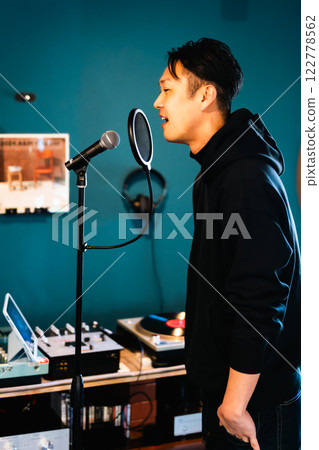 一名年輕人在音響設備前錄音 一名年輕人在音響設備前錄音 122778562